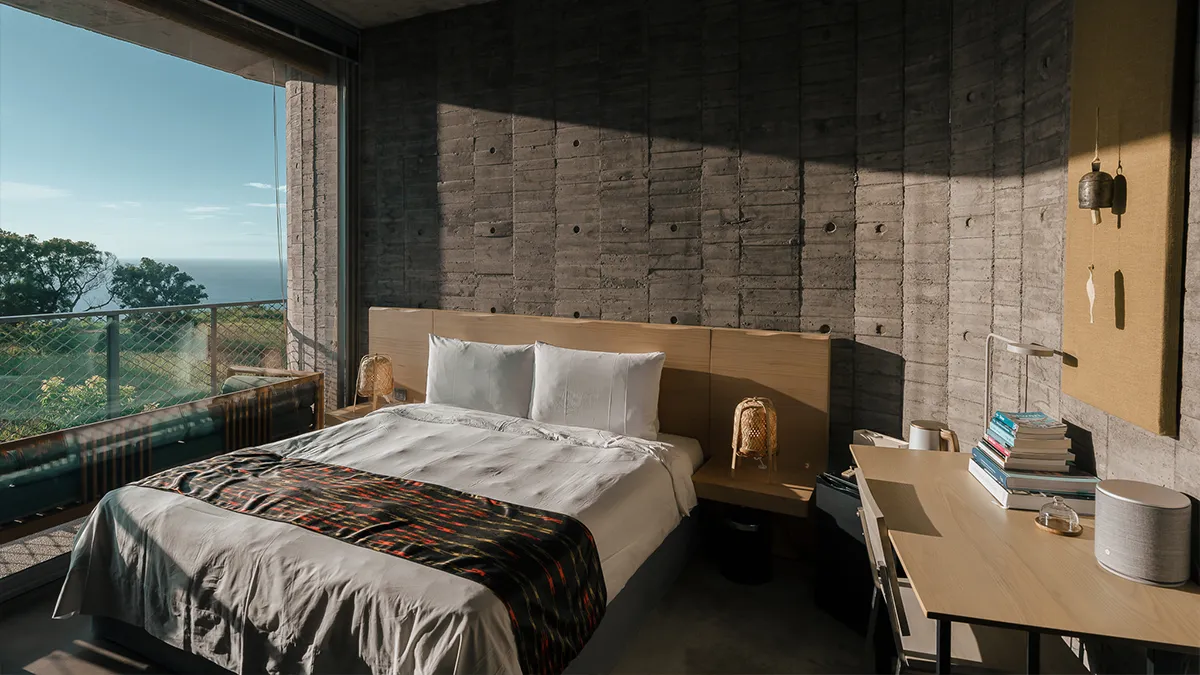 台 灣唯一入選世界百大建築的旅宿，順應落山風的流動，以 圓弧石牆環抱自然