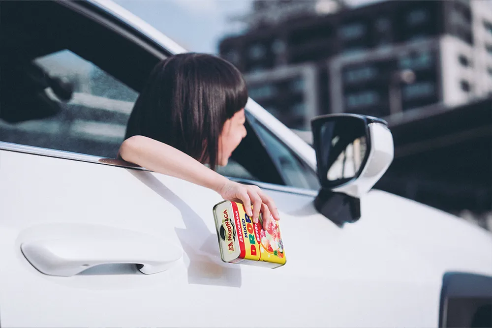 薛越的女兒從車窗拿出糖果